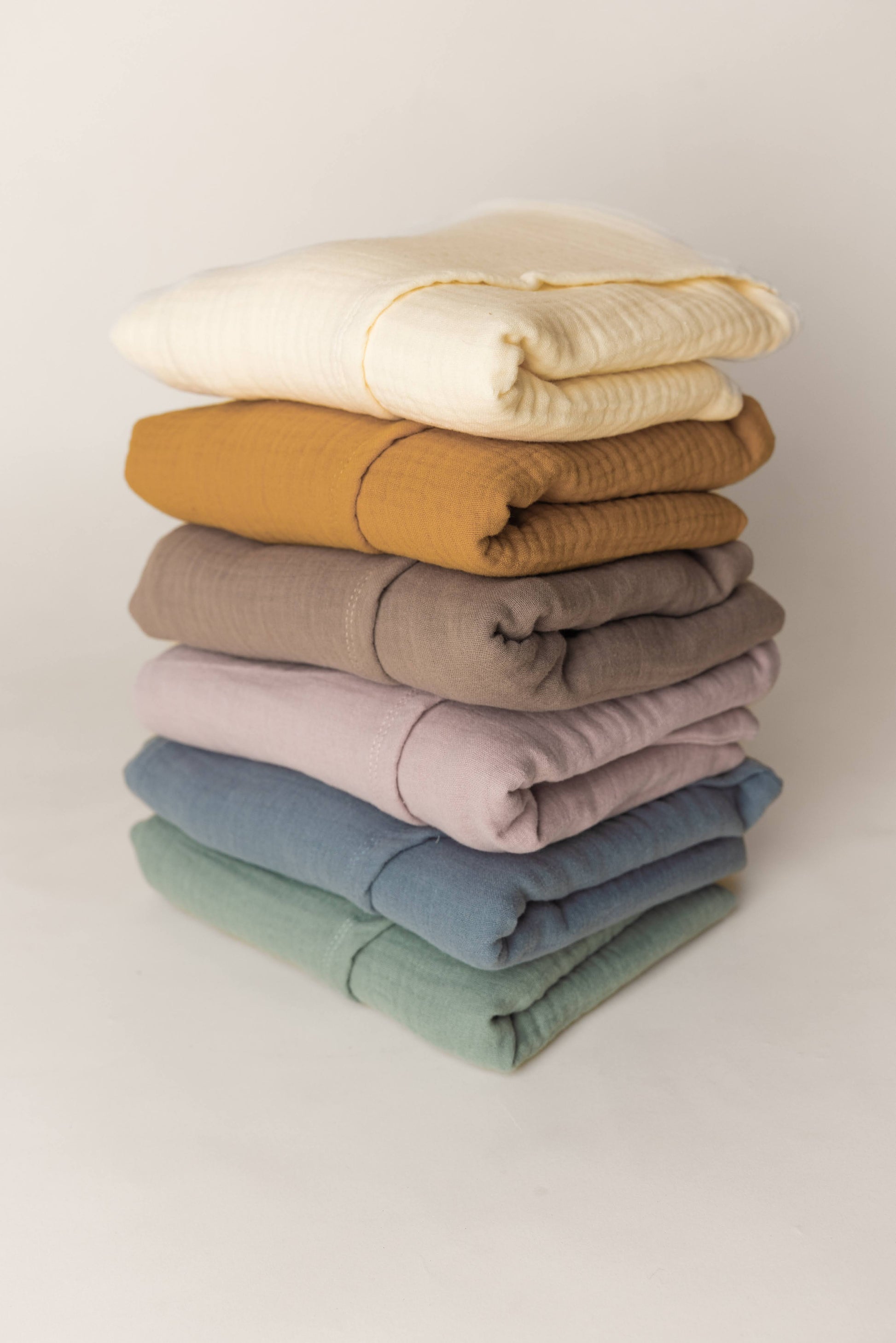 Stack of folded covers in various colors on a light background